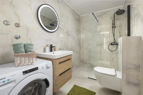 a bathroom with a washer and dryer in it at Olive Breeze in Brela