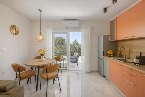 a kitchen and dining room with a table and chairs at Olive Breeze in Brela