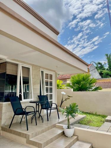 a patio with chairs and a table in front of a house at Villa Sultana Malang in Malang