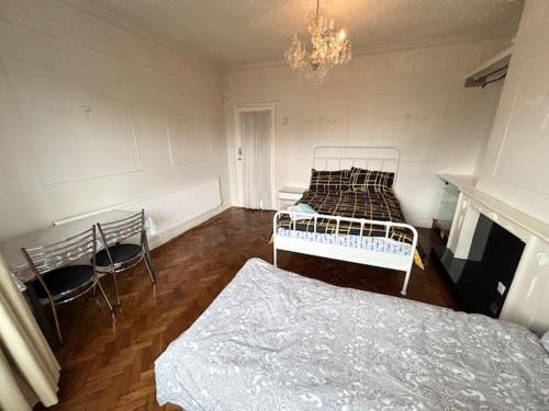 a room with two beds and a fireplace and a chandelier at Double Bedroom Near Heathrow Airport & London in Hayes