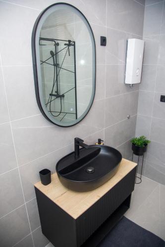 a bathroom with a black sink and a mirror at Apartman Puente Viejo Mostar in Mostar