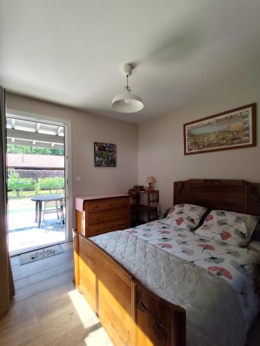 une chambre avec un lit et une porte coulissante en verre dans l'établissement Le petit nid dans les bois, à Castres-Gironde