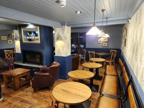 a restaurant with tables and chairs and a fireplace at The Swan - A Colombo Edition Hotel in Ely