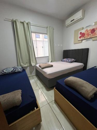 a bedroom with two beds and a window at Noel Rosa Building in Foz do Iguaçu