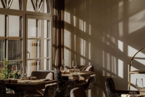a dining room with tables and chairs and shadows on the wall at Hotel Auerhahn in Schluchsee
