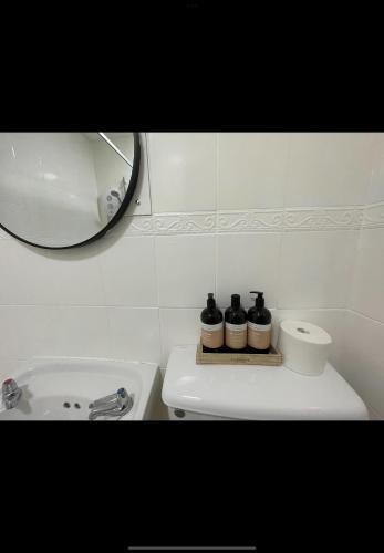 a white bathroom with a sink and a mirror at Admiralty House in Weymouth