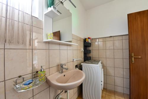 a bathroom with a sink and a heater at Apartman Katja in Rakovica