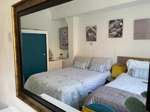 ein Schlafzimmer mit zwei Betten und einem Spiegel in der Unterkunft Admiralty House in Weymouth