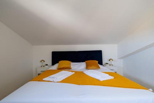 a bedroom with a bed with two towels on it at Villa Belvue - Big Pool & Private Parking - 500m Sea in Medulin