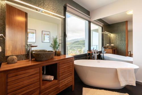a bathroom with a large tub and a sink at Valley View-Villa with heated pool and sauna in Arco da Calheta