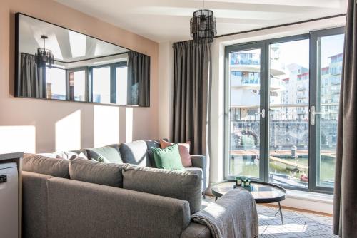 a living room with a couch and a large window at Boat House - Luxe Apt with River View - Next to Harbour & Cafes in Bristol