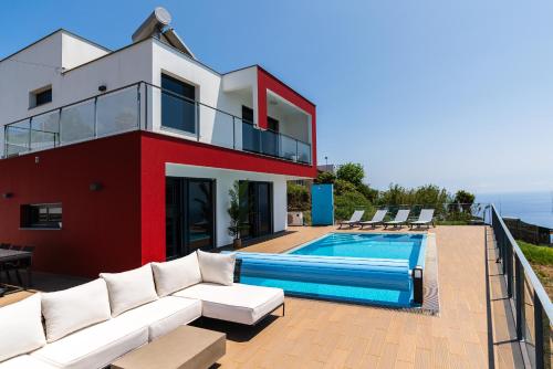 a house with a swimming pool next to a house at Valley View-Villa with heated pool and sauna in Arco da Calheta