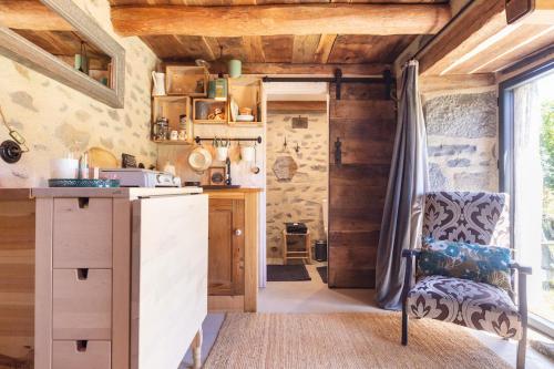 - une cuisine avec un comptoir et une chaise dans une pièce dans l'établissement La Loge de Rose, à Peyrelade