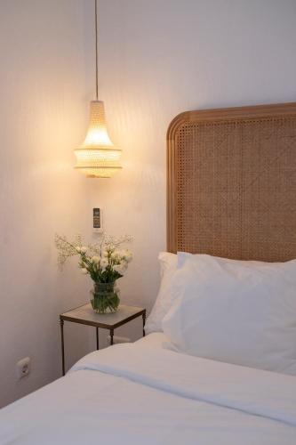 a bedroom with a bed and a vase of flowers on a table at La Morada Mas Hermosa in Marbella