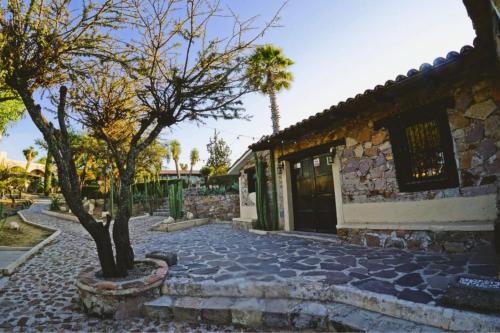 a stone house with a tree and a building at Hotel Casa FERNALI in Bernal