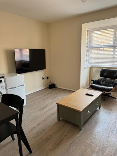 a living room with a coffee table and a flat screen tv at 11 York House apartment in Kettering