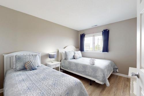 a bedroom with two beds and a window at East of the Sun --- 39620 E Sun Dr #717 in Fenwick Island