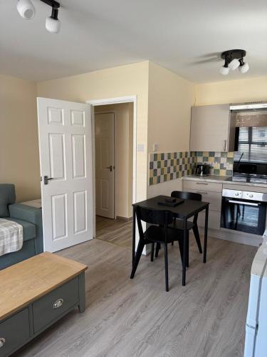 a living room with a table and a kitchen at 11 York House apartment in Kettering