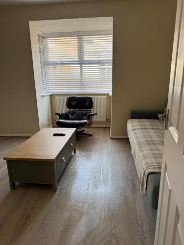 a room with a bed and a chair and a table at 11 York House apartment in Kettering