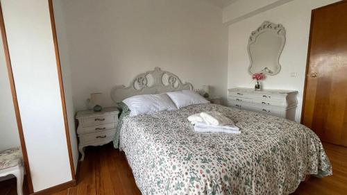 a bedroom with a bed and two dressers and a mirror at Amanecer Combarro in Combarro