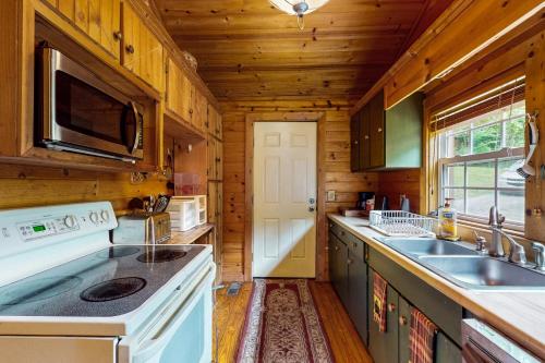 a kitchen with a white stove and a sink at Rustic Getaway in Topton