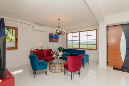a living room with a blue couch and red chairs at Luxury Villa Dobri Dida in Imotski