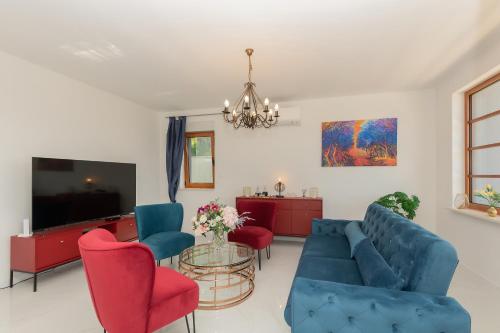 a living room with a blue couch and red chairs at Luxury Villa Dobri Dida in Imotski