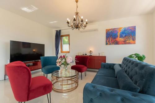 a living room with a blue couch and red chairs at Luxury Villa Dobri Dida in Imotski