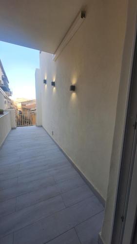 an empty hallway with a white wall and lights at Agrigento Zefiro Rooms in Agrigento
