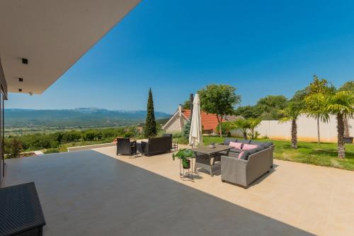 a house with a patio with a table and chairs at Luxury Villa Dobri Dida in Imotski