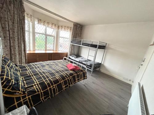 a bedroom with a bed and bunk beds in it at Double Bedroom Near Heathrow Airport & London in Hayes