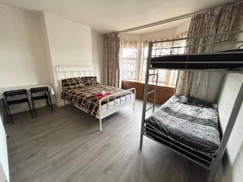 a bedroom with two bunk beds and a window at Double Bedroom Near Heathrow Airport & London in Hayes