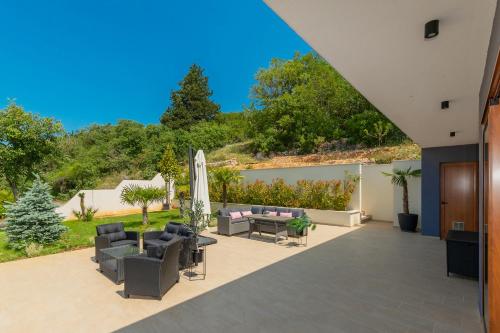 a patio with two couches and an umbrella at Luxury Villa Dobri Dida in Imotski
