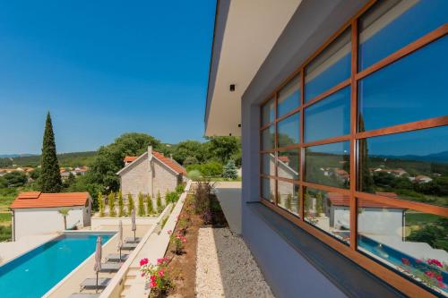a house with a swimming pool and a window at Luxury Villa Dobri Dida in Imotski