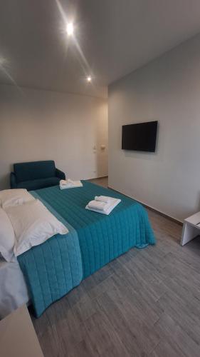a bedroom with a bed and a flat screen tv at Agrigento Zefiro Rooms in Agrigento