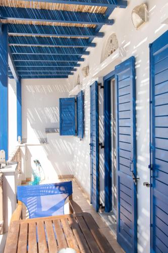 a porch with blue doors and a bench at Casa Chora by Sea ALure in Tinos