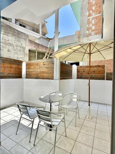 a patio with a table and chairs and an umbrella at Azzurro in Paleros