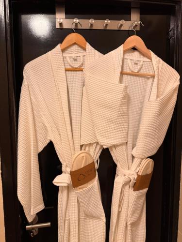 two white sweaters are hanging on a door at Décor Canal House in Amsterdam