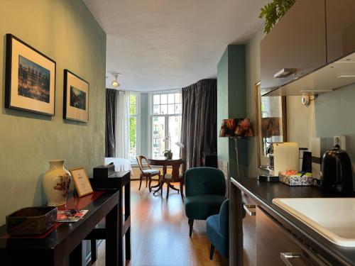 a kitchen and living room with a table and chairs at Décor Canal House in Amsterdam