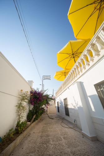 a yellow umbrella on the side of a building at Albergo Europa in Marina di Mancaversa