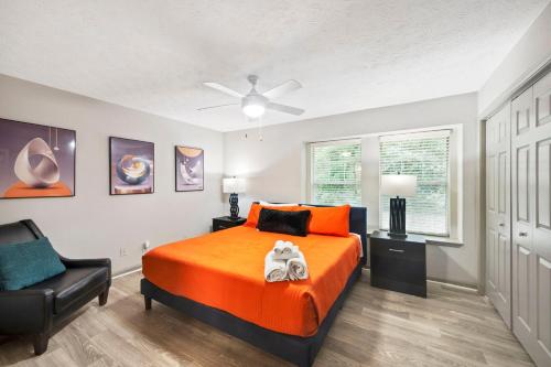 Un dormitorio con una cama naranja y una silla. en King Bed 5 min walk Truist Park The Battery, en Atlanta