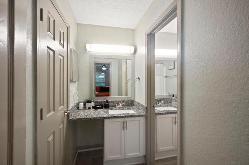 Un baño con dos lavabos y un espejo. en King Bed 5 min walk Truist Park The Battery, en Atlanta