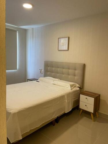a bedroom with a large bed and a night stand at Chipe Apartment in Piura