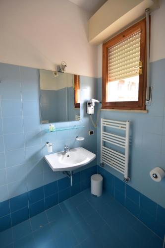 a blue bathroom with a sink and a mirror at Residence Avana in Senigallia