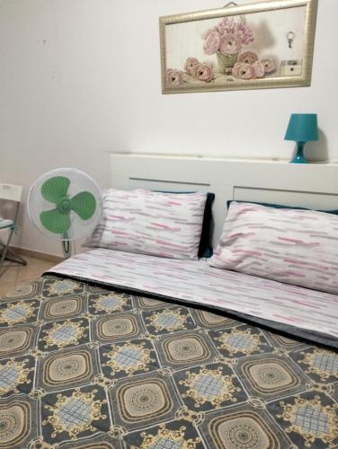 a bedroom with two beds and a table and a fan at La Perla B & B in Ciampino