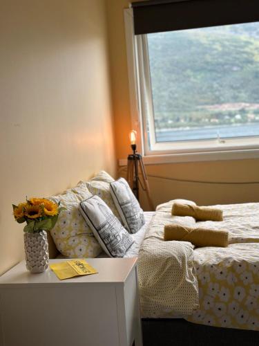 a bedroom with a bed with a window and a table at Tjeldøya Slott in Hov