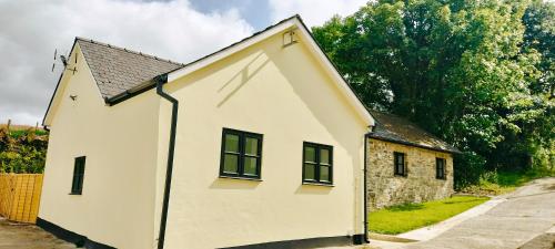 a white house with two windows on the side of it at Dog friendly rural location in Llanerch-Aeron