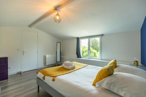 une chambre avec un grand lit avec un animal en peluche dessus dans l'établissement La Pierre Blanche - Maison Familiale, à Saint-Georges-sur-Cher