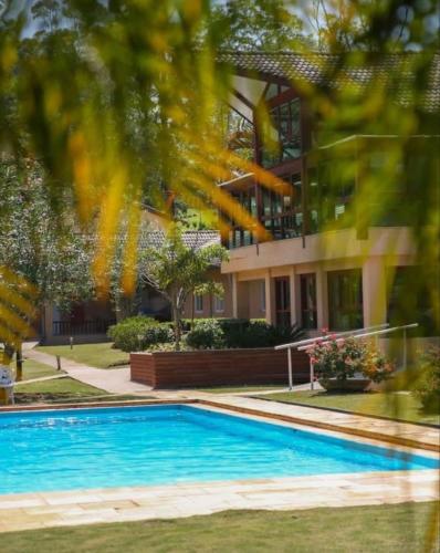 a house with a swimming pool in front of a building at Clínica e Spa Vida Natural in São Roque