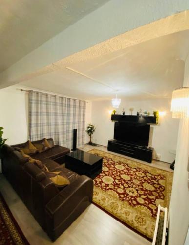 a living room with a couch and a piano at Surrey Hills Retreat - 2-Bed - Easy London Access in Ash